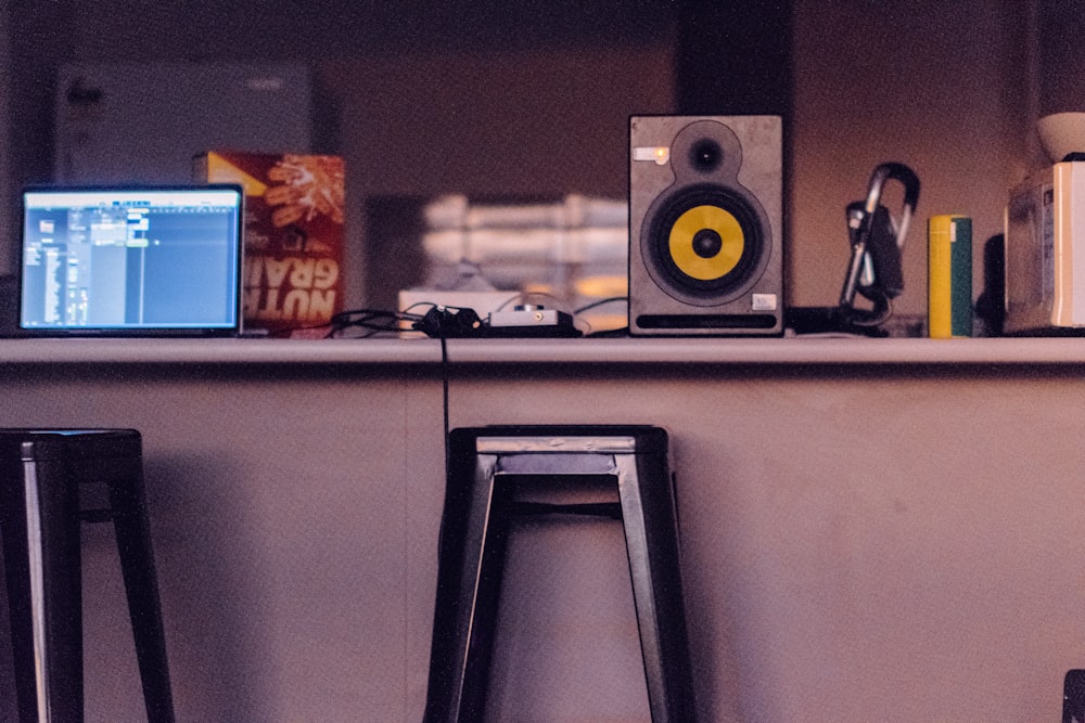 a desk with a laptop and speakers on it