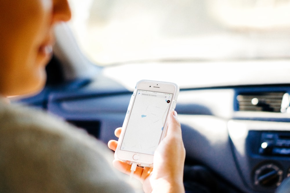 a woman holding a cell phone in a car