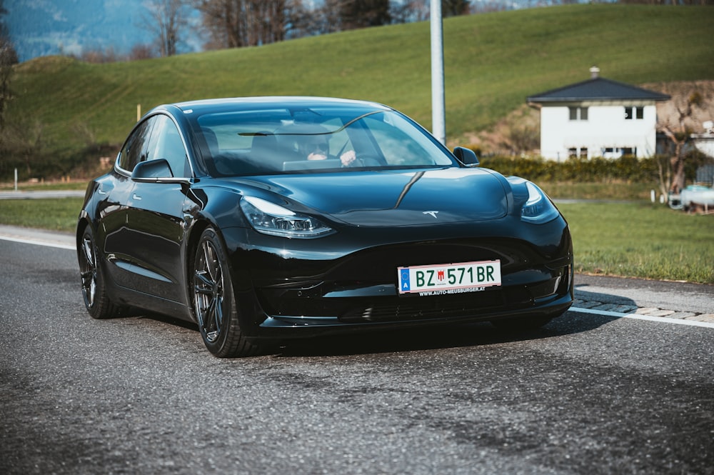 a black car is parked on the side of the road