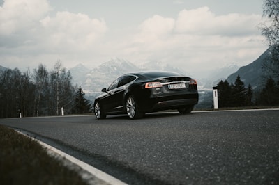 A sleek car driving safely on a scenic road, representing auto insurance.