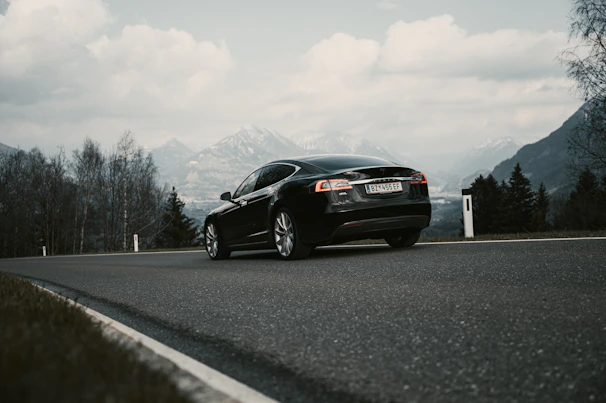 A sleek car on a scenic road, representing comprehensive vehicle insurance.