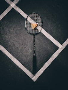 a tennis racket with a piece of cheese on it