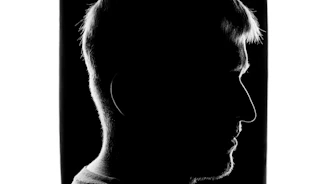 Silhouette of a human head with a striking contrast of light and shadow, symbolizing consciousness.