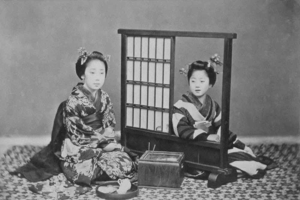 an old photo of two women sitting next to each other