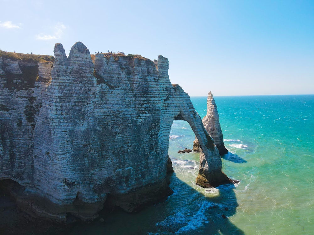 a large rock formation in the middle of a body of water