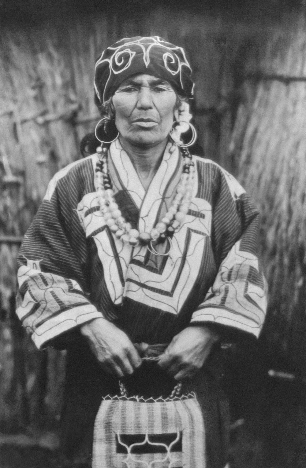 a black and white photo of a woman in native clothing