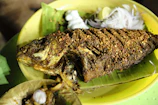 Close-up of a traditional Banten spicy grilled fish served on a banana leaf