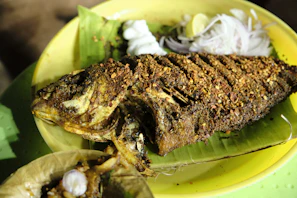 Close-up of traditional Bantenese spicy grilled fish served on a banana leaf