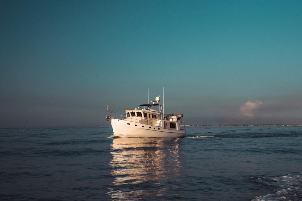 a white boat floating on top of a body of water