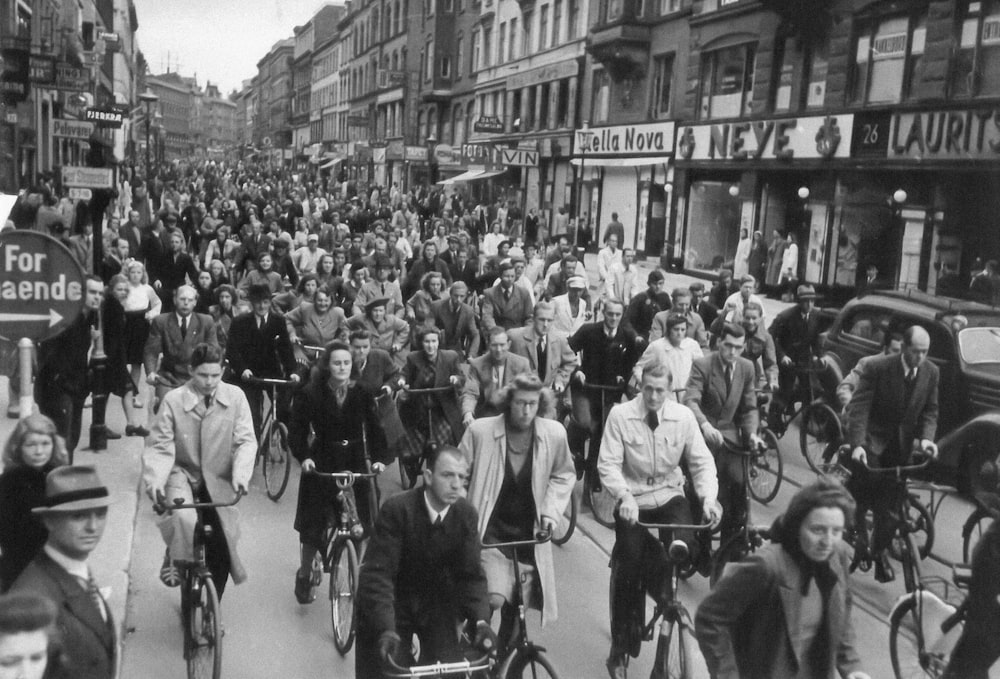 a large group of people riding bikes down a street