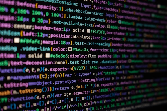 The image features colorful lines of code on a computer screen, showcasing various syntax elements with different colors to highlight keywords, values, and functions. The background is dark, enhancing the visibility of the text.