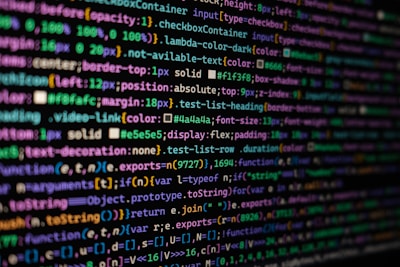 The image features colorful lines of code on a computer screen, showcasing various syntax elements with different colors to highlight keywords, values, and functions. The background is dark, enhancing the visibility of the text.