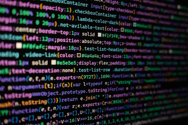 The image features colorful lines of code on a computer screen, showcasing various syntax elements with different colors to highlight keywords, values, and functions. The background is dark, enhancing the visibility of the text.