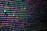 The image features colorful lines of code on a computer screen, showcasing various syntax elements with different colors to highlight keywords, values, and functions. The background is dark, enhancing the visibility of the text.