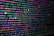 The image features colorful lines of code on a computer screen, showcasing various syntax elements with different colors to highlight keywords, values, and functions. The background is dark, enhancing the visibility of the text.