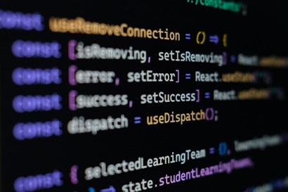 Computer screen displaying lines of JavaScript code. Variables and methods appear, with syntax highlighting in different colors such as purple, yellow, blue, and white against a black background.