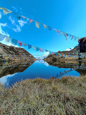 A serene Qinghai lake reflecting colorful prayer flags fluttering in the mountain breeze.