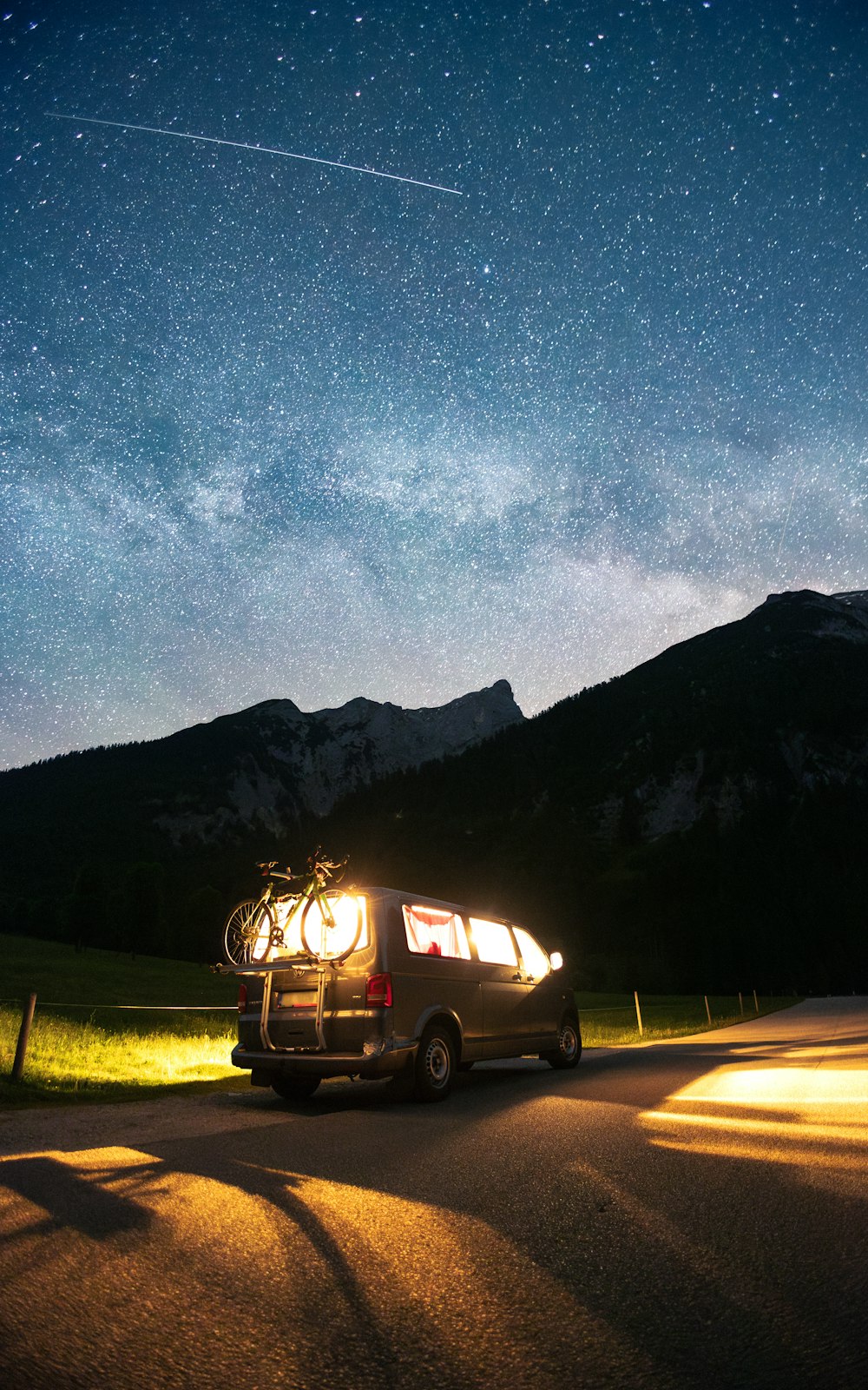 a van parked on the side of a road under a night sky