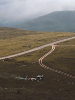 A panoramic shot of a remote Australian outback campsite with rugged terrain and gear.