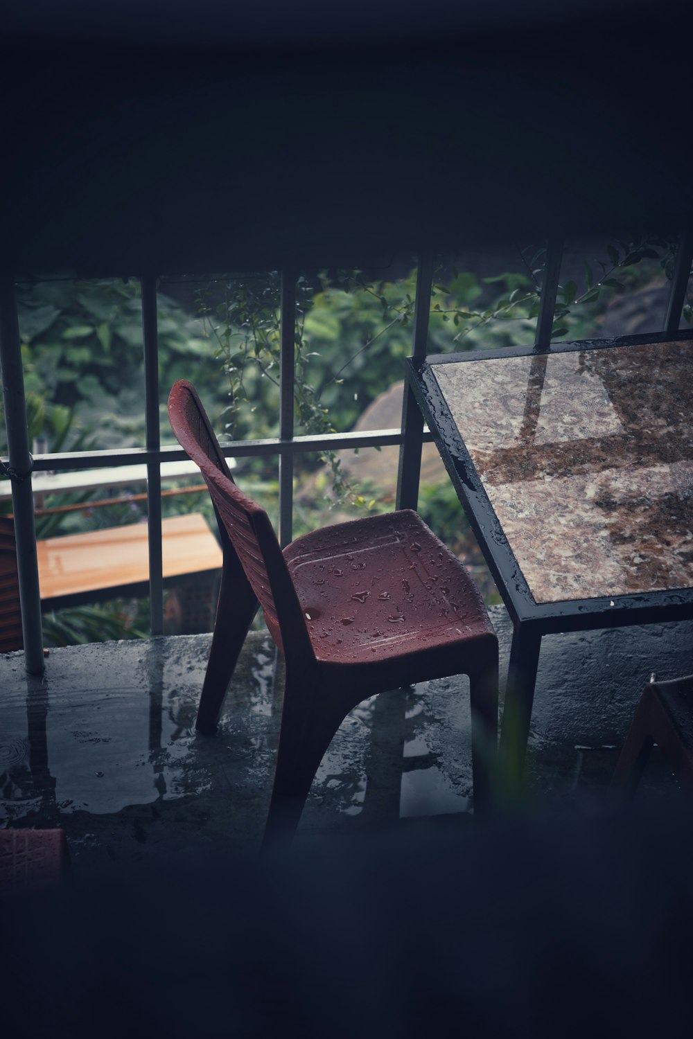 a red chair sitting next to a wooden table