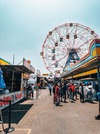 A vibrant image of attendees enjoying the fair with colorful stalls in the background.
