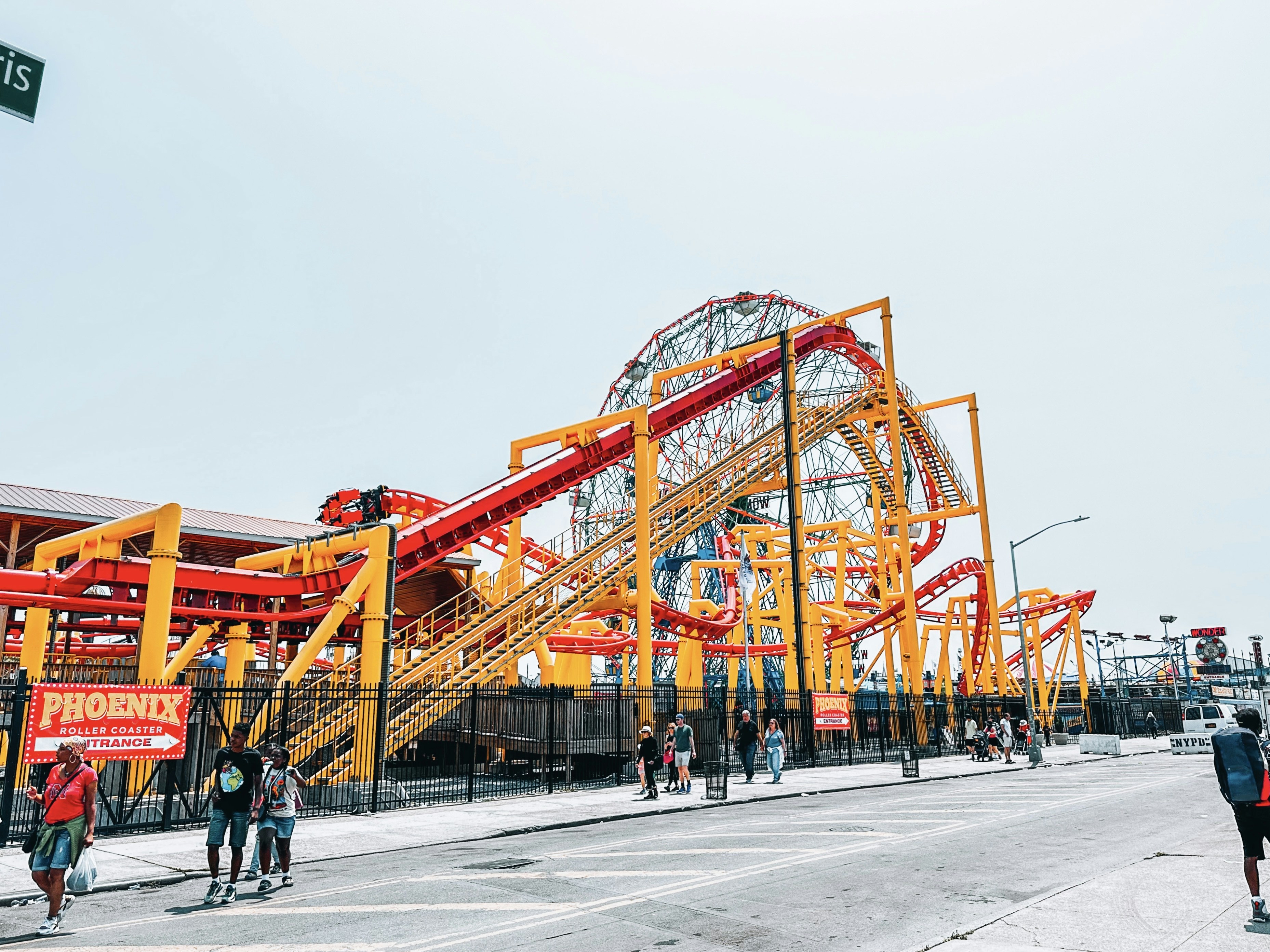 a group of people standing around a roller coaster