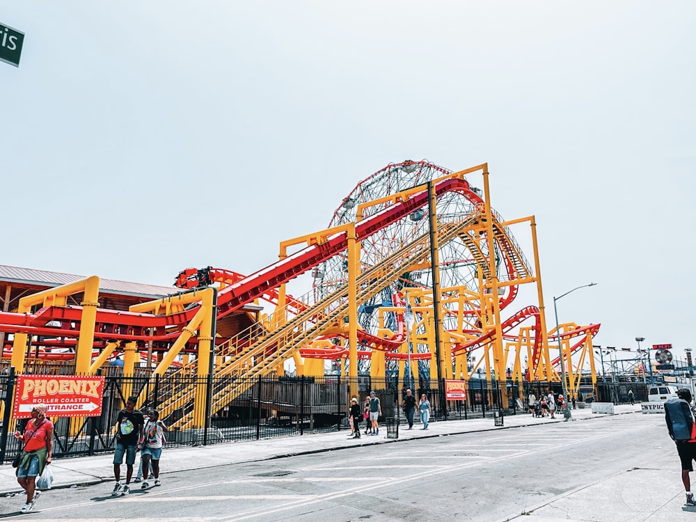 a group of people standing around a roller coaster