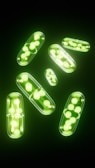 green pills are arranged on a black background