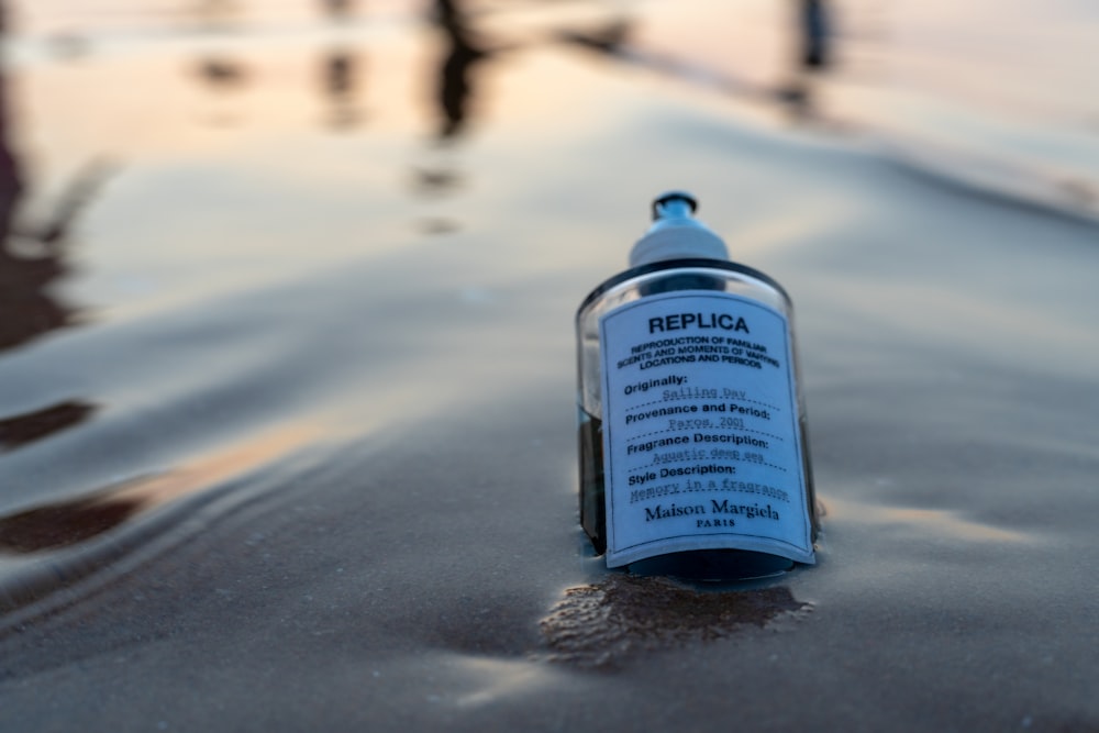 a bottle with a label on it sitting in the sand