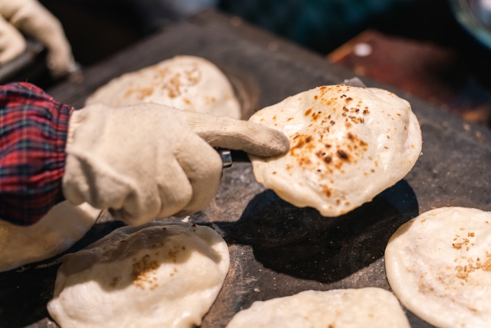 a person in gloves is making food on a grill