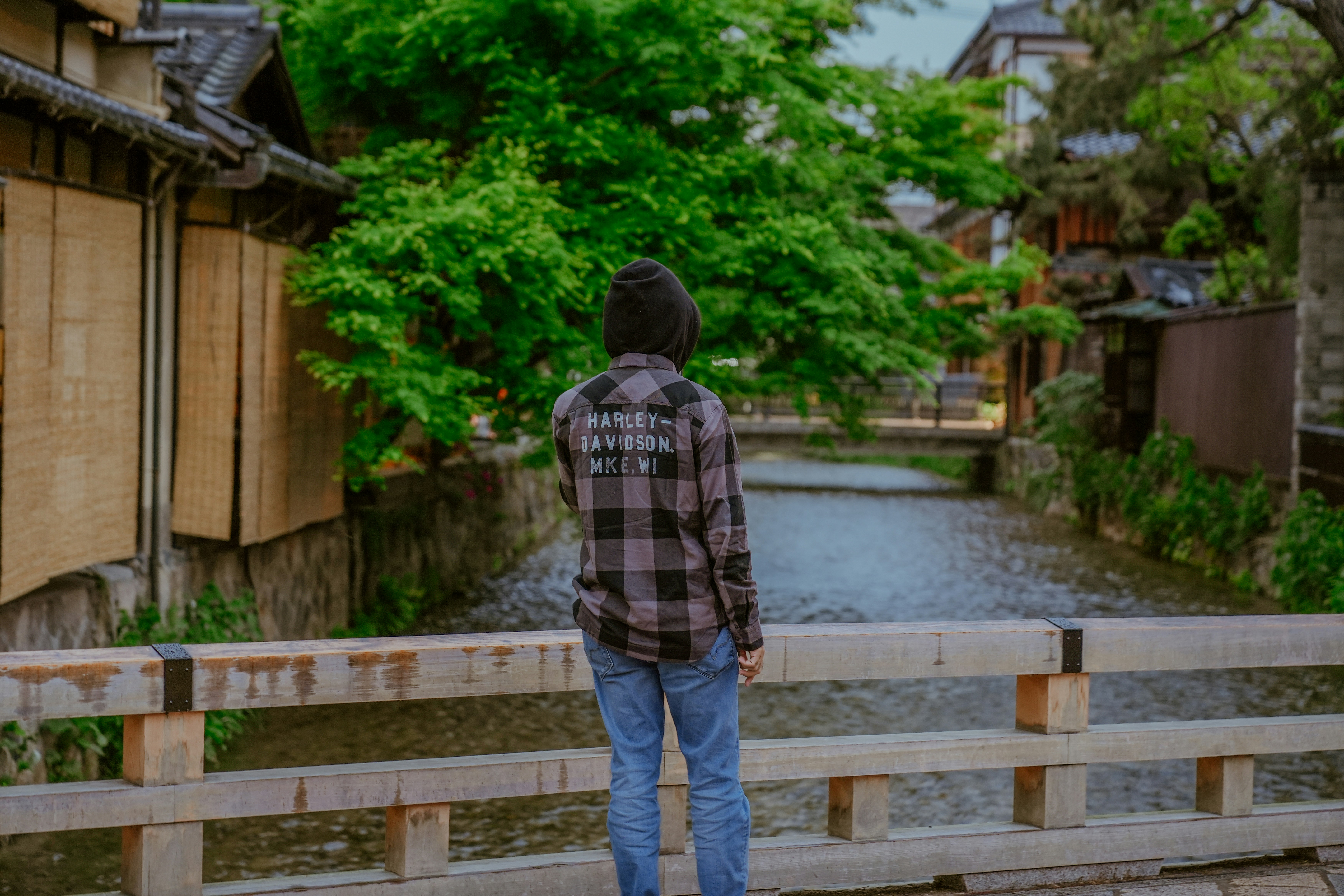 Un homme debout sur un pont regardant une rivière