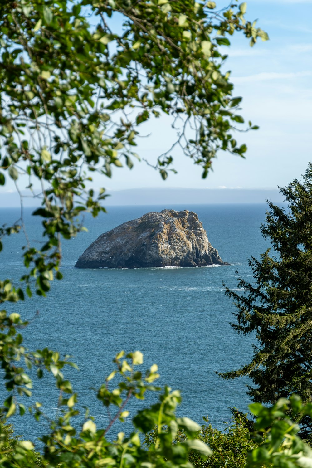 a large rock in the middle of a body of water