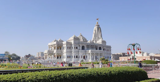 a large white building sitting next to a lush green park