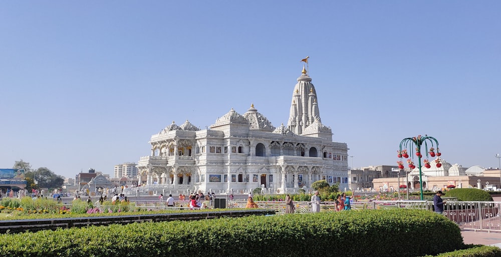 a large white building sitting next to a lush green park