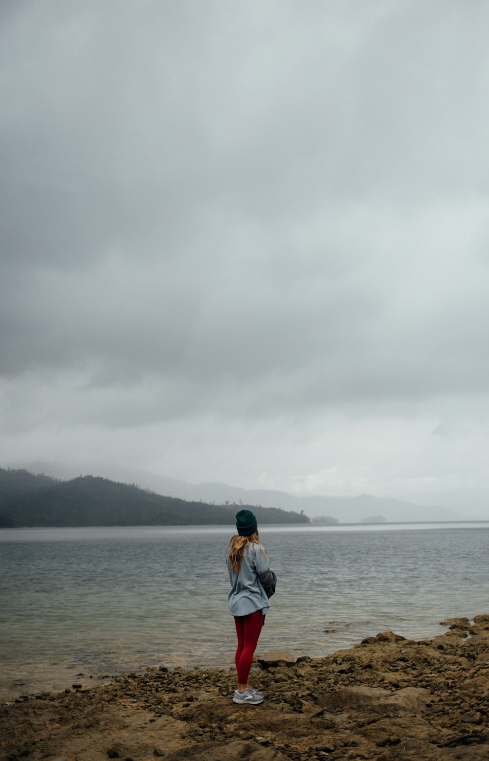 a woman standing on top of a sandy beach