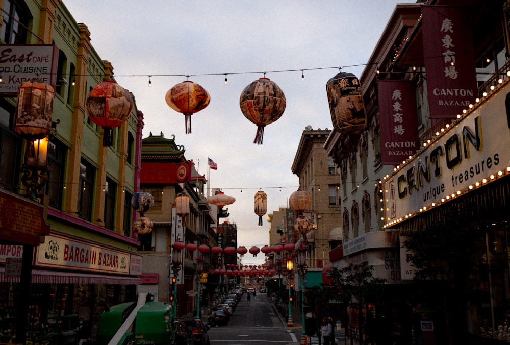 a city street lined with buildings and lanterns