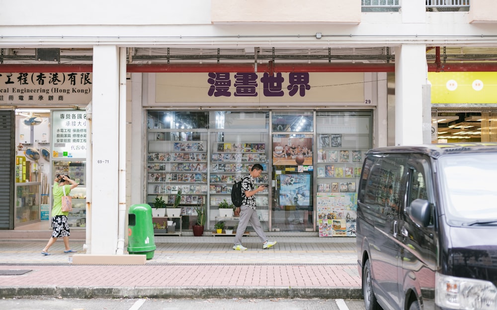 a couple of people walking past a store front