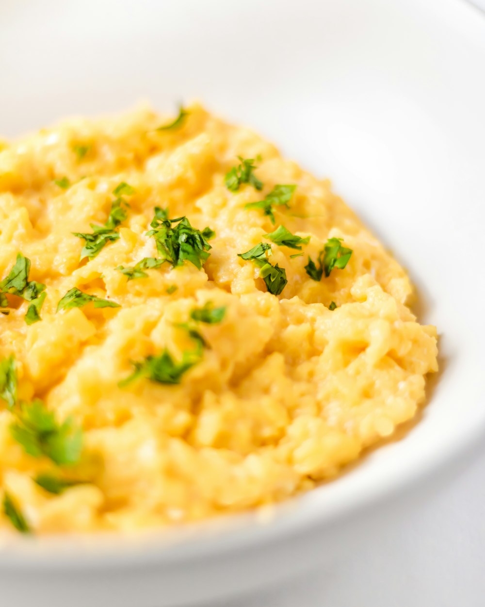 a bowl of mashed potatoes with parsley on top