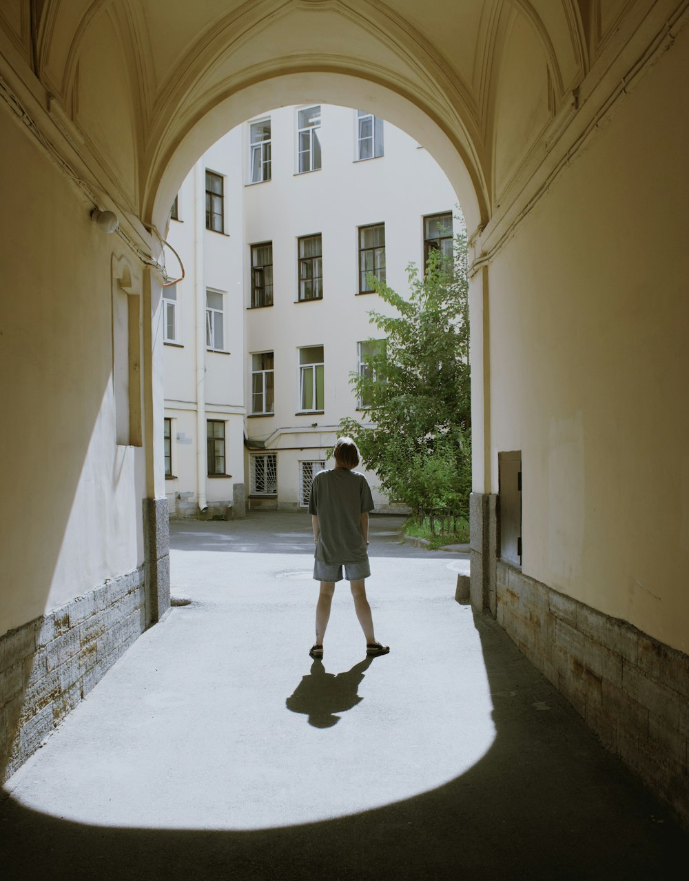 a person standing in an archway between two buildings