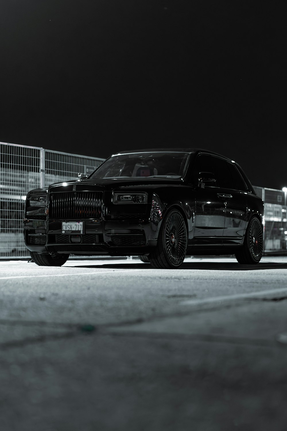 a black car parked in a parking lot at night