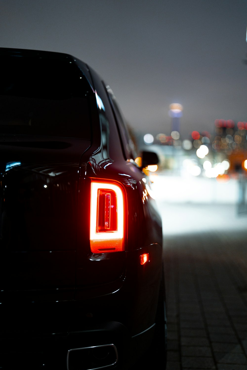 Foto zum Thema Die Rücklichter eines schwarzen Autos bei Nacht –  Kostenloses Bild zu RollsRoyceCullinan auf Unsplash