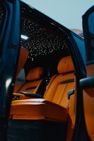 Interior view of a spacious luxury car with plush leather seats and ambient lighting.