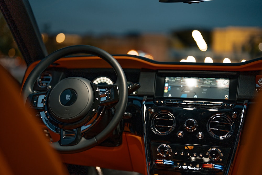 the dashboard of a car with a lot of lights in the background