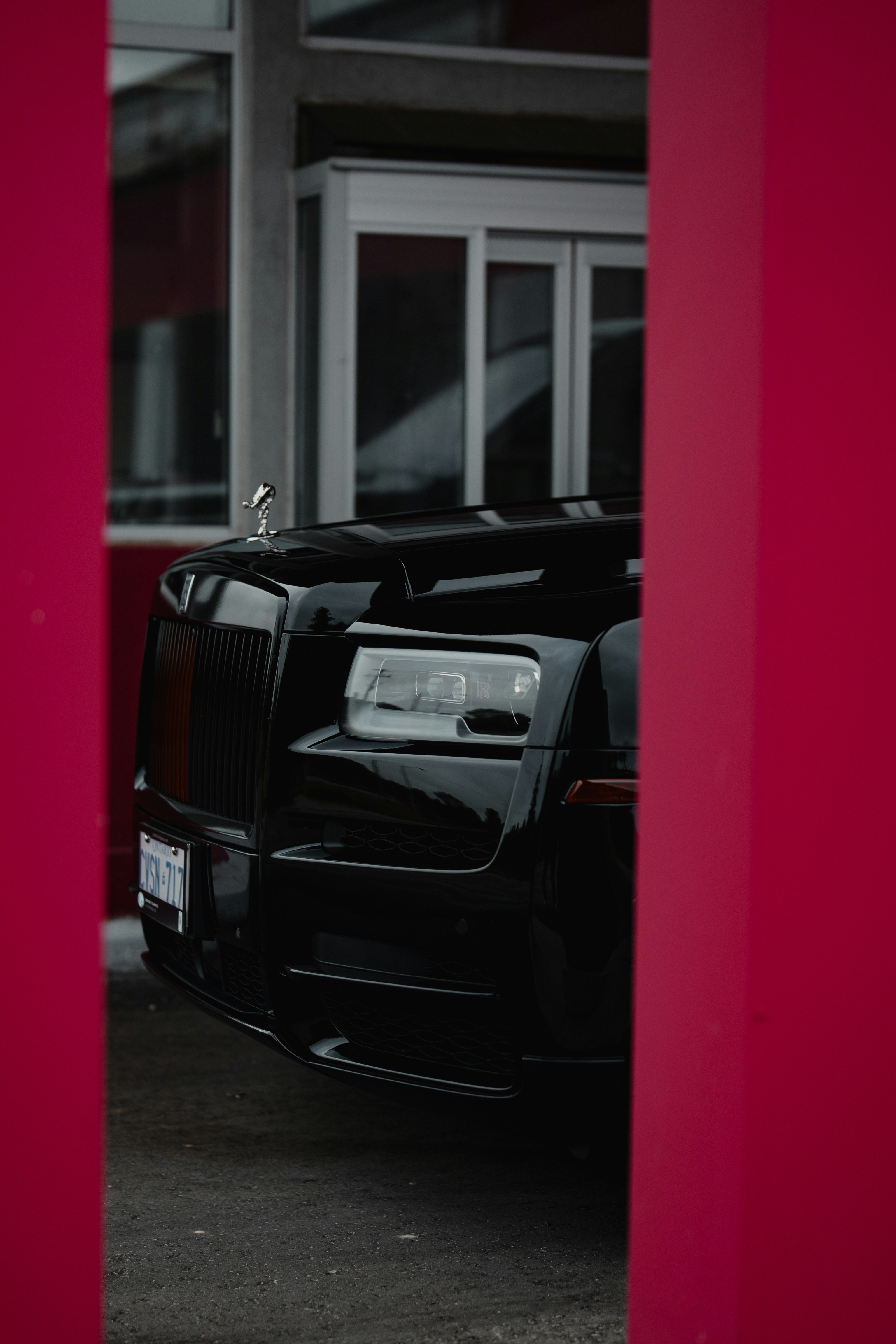 Una Rolls Royce nera parcheggiata davanti a un edificio