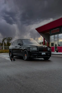 A sleek black SUV parked in front of a modern Casablanca apartment building at sunset.