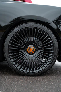 Aggressive yellow-accented emblem mounted on a custom rim, reflecting speed and luxury.