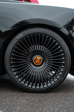 Aggressive yellow-accented emblem mounted on a custom rim, reflecting speed and luxury.
