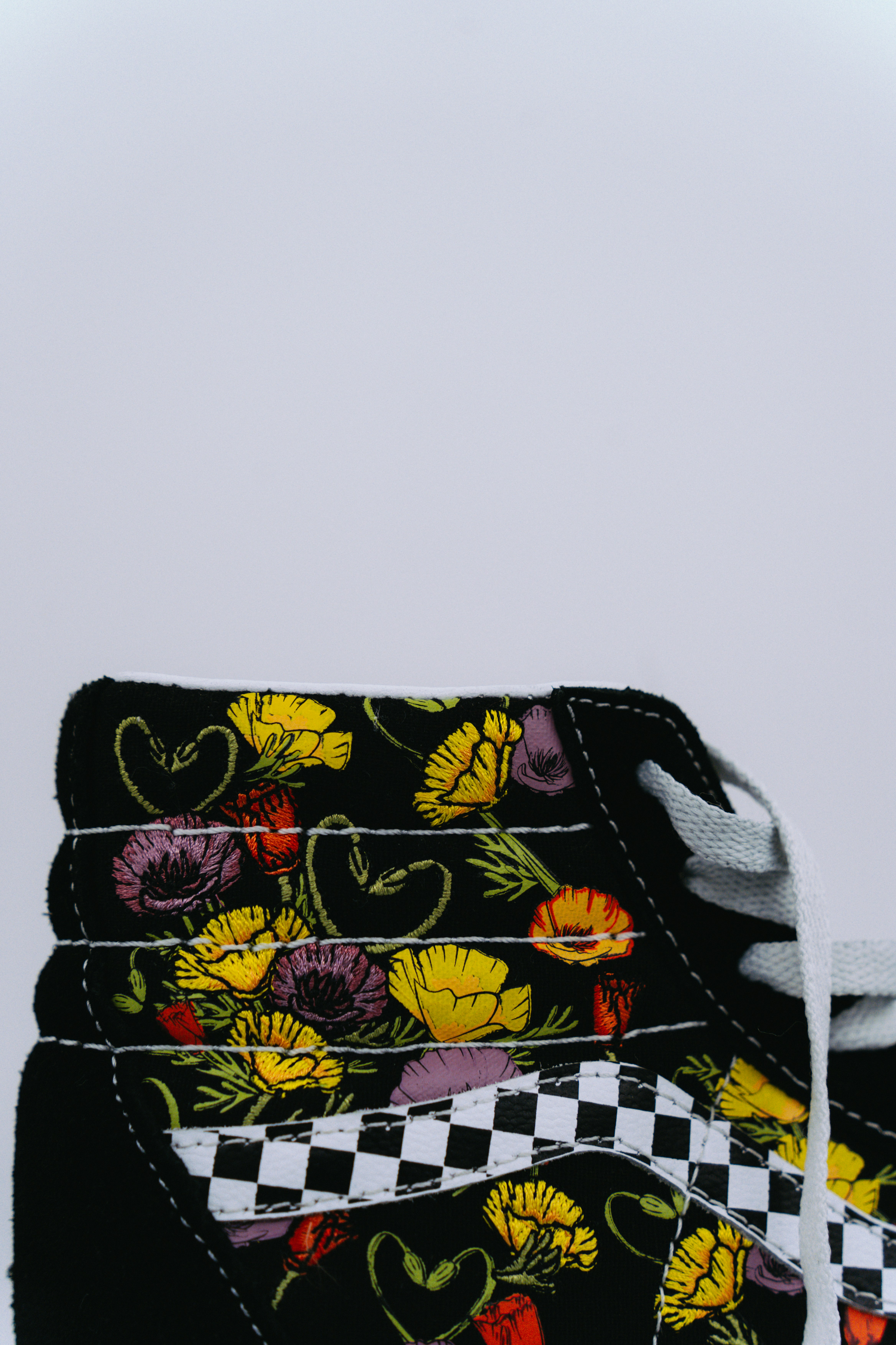 a pair of black and yellow shoes with flowers on them
