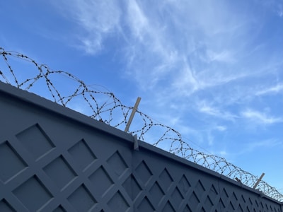 A sturdy precast RCC boundary wall surrounding a spacious farm plot under a clear blue sky.