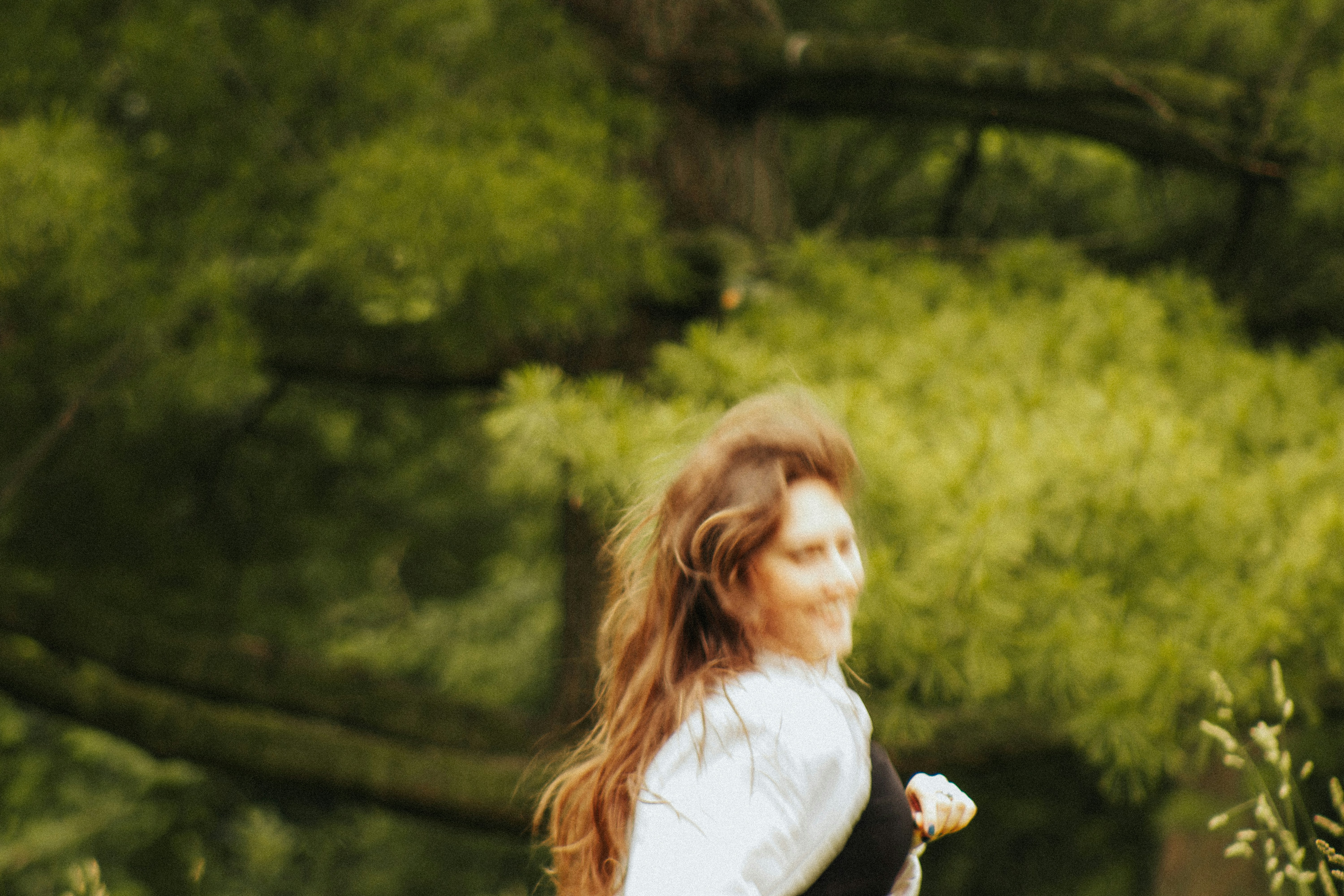 Eine Frau in weißem Hemd und schwarzer Hose wirft eine Frisbee